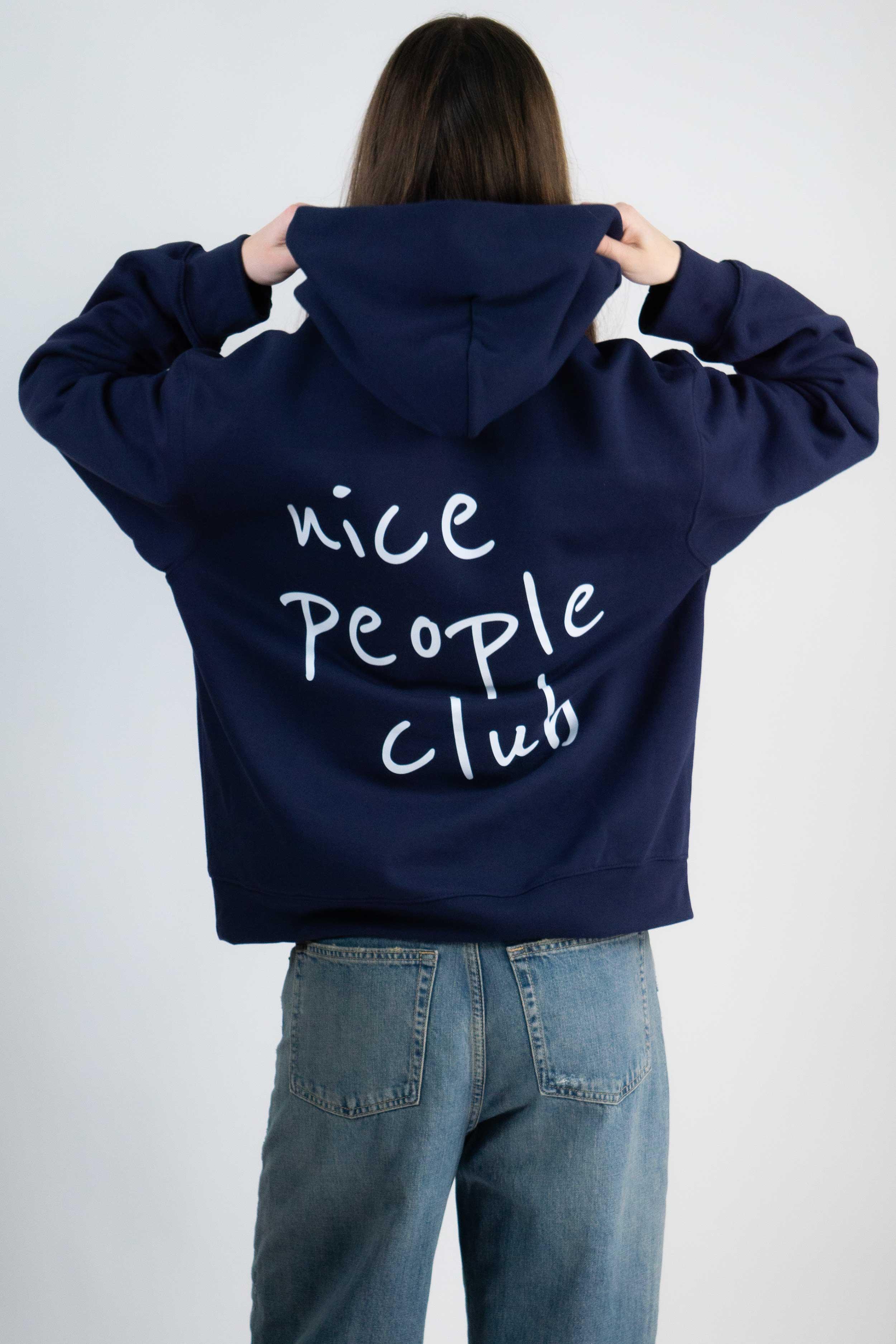 Person wearing a navy hoodie with 'nice people club' text on the back, standing against a white background.